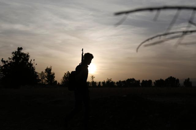 A Syrian rebel fighter holds his weapon as the sun sets over the rebel-controlled village of Bala, in the eastern Ghouta region on the outskirts of the capital Damascus. (AFP Photo)