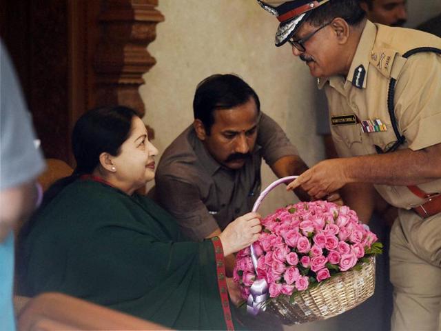 Tamil Nadu Chief Minister and AIADMK Supremo J Jayalalithaa receiving a floral bouquet from City Police Commissioner Ashutosh Shukla after her party's win in the state Assembly polls in Chennai. (PTI) 