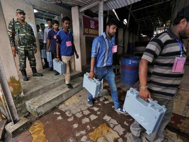 Election officials carry electronic voting machines (EVM) as they arrive to count votes in the West Bengal Assembly elections, at a counting center in Kolkata. (REUTERS)