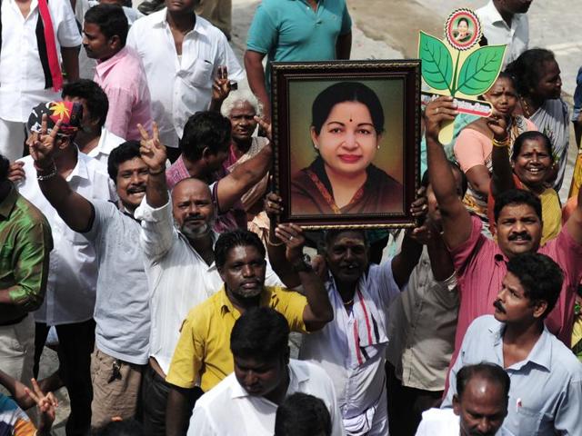 Members of the AIADMK party carry placards with the image of AIADMK leader Jayalalithaa Jayaram as they celebrate in front of her residence in Chennai on May 19, 2016. (AFP)