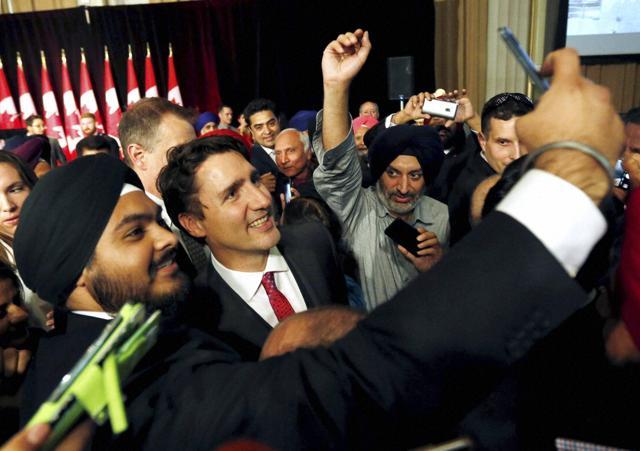 Prime Minister Justin Trudeau (centre) smiles as a Sikh man takes a selfie with him after he delivered remarks at the Komagata Maru Apology reception in Ottawa on Wednesday. (AP)
