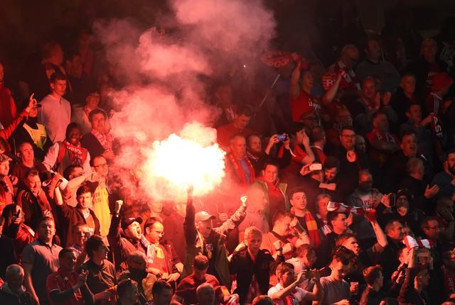 Liverpool fans celebrate with a flare. (REUTERS)