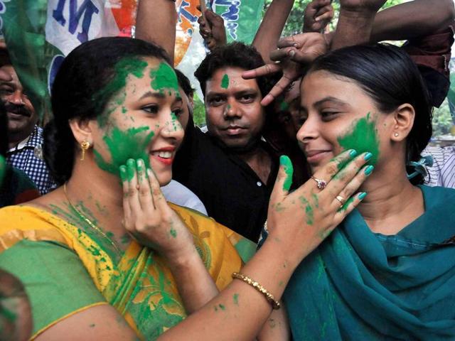 Trinamool Congress workers smear color on each other as they celebrate the party's thumping victory in West Bengal Assembly elections, in Kolkata on Thursday. (PTI)
