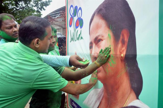 TMC supporters throw colour at West Bengal CM and party chief Mamata Banerjee's poster after the party's thumping win in West Bengal Assembly elections. (PTI) TMC supporters throw colour at West Bengal CM and party chief Mamata Banerjee's poster after the party's thumping win in West Bengal Assembly elections. (PTI)