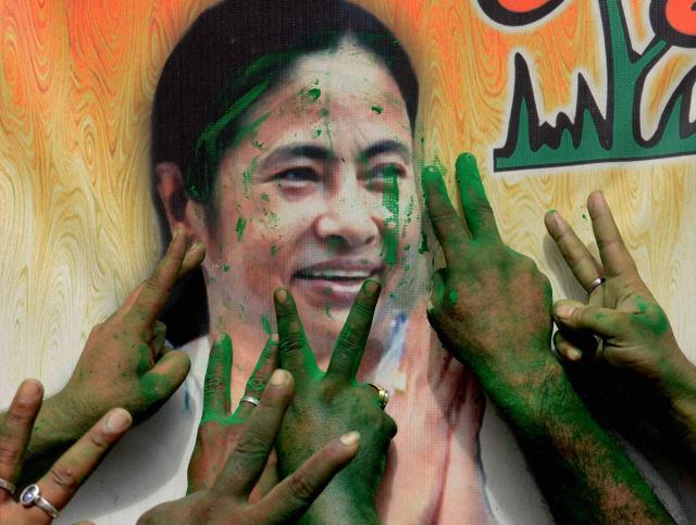TMC supporters throw colour at West Bengal CM and party chief Mamata Banerjee's poster after the party's thumping win in West Bengal Assembly elections. (PTI) TMC supporters throw colour at West Bengal CM and party chief Mamata Banerjee's poster after the party's thumping win in West Bengal Assembly elections. (PTI)