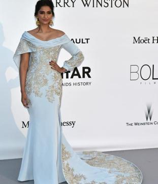 Sonam Kapoor wore a gold embroidered Ralph & Russo gown, accessorised it with jhumkas, and accentuated by minimal makeup at the amfAR Gala on Thursday. (AFP) 