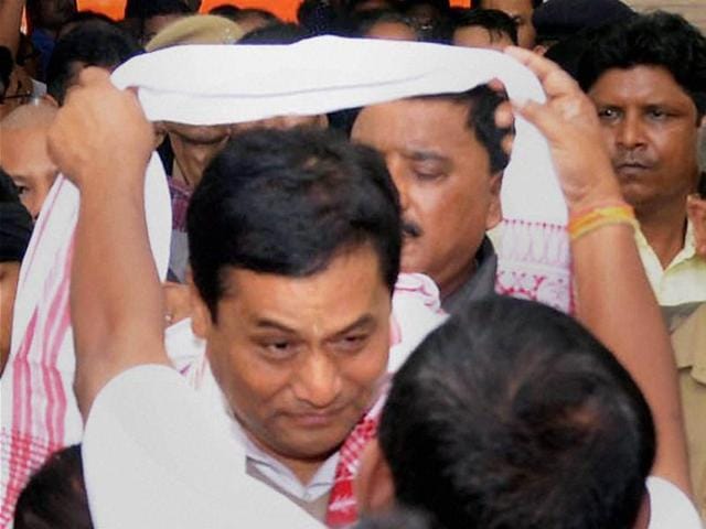BJP’s chief ministerial candidate, Sarbanada Sonowal, is greeted on his arrival for a meeting with the newly elected party legislators at the party office at Hengrabari in Guwahati.(PTI)