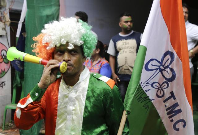 A supporter of the All India Trinamool Congress party dressed in party colours celebrate after winning the West Bengal state assembly elections, in Kolkata on Thursday. (AP) A supporter of the All India Trinamool Congress party dressed in party colours celebrate after winning the West Bengal state assembly elections, in Kolkata on Thursday. (AP)