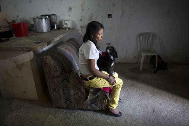 In this May 10, 2016 photo, Argelia Gamboa, Roberto Bernal's widow, sits on a sofa with a family pet, in a hillside slum in Caracas, Venezuela. (AP) In this May 10, 2016 photo, Argelia Gamboa, Roberto Bernal's widow, sits on a sofa with a family pet, in a hillside slum in Caracas, Venezuela. (AP)