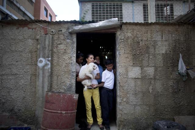 In this May 10, 2016 photo, members of Roberto Bernal's family stand in the doorway of their home in a hillside slum in Caracas, Venezuela. (AP) In this May 10, 2016 photo, members of Roberto Bernal's family stand in the doorway of their home in a hillside slum in Caracas, Venezuela. (AP)