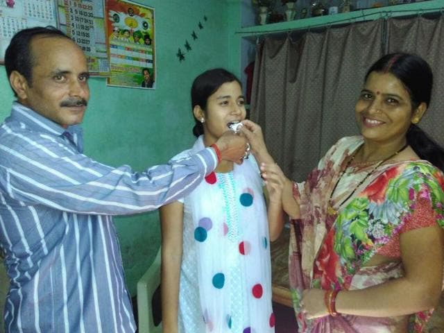 Saloni Maurya with her parents. She topped Lucknow’s St Anjani’s Public School by scoring 97% in the science stream.(Handout image) Saloni Maurya with her parents. She topped Lucknow’s St Anjani’s Public School by scoring 97% in the science stream.(Handout image)