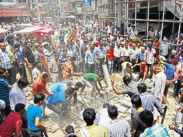 Shopkeepers destroying a structure constructed for installing bollards near the Golden Temple on Friday. (Sameer Sehgal/HT)