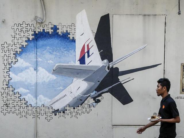 In this file photo, a man walks past a mural of flight MH370 in Shah Alam outside Kuala Lumpur, Malaysia. (AP File Photo) In this file photo, a man walks past a mural of flight MH370 in Shah Alam outside Kuala Lumpur, Malaysia. (AP File Photo)