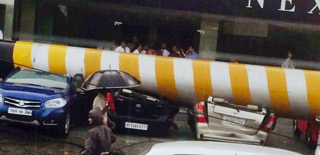 A billboard pillar smashed in to cars when it fell due to strong winds on Friday in Hyderabad. (PTI)