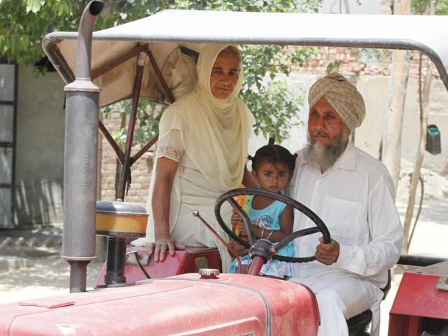 Sangrur couple Darbara Singh, 55, and Jasmail Kaur, 55, with their two- year-old daughter Manwinder Kaur in the village of Kheri.(JS Grewal/Hindustan Times)