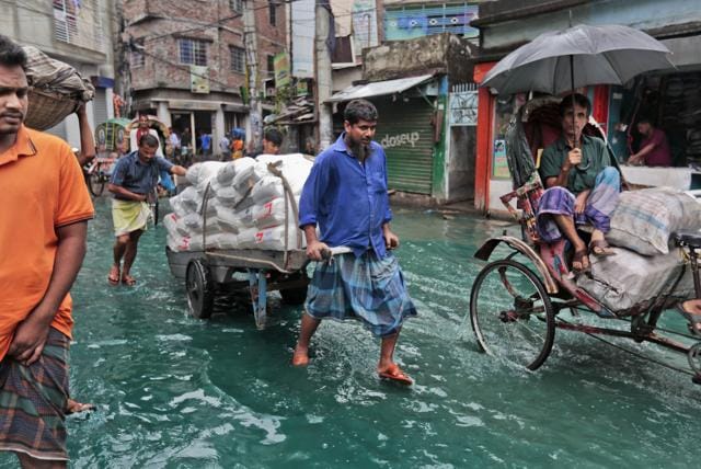 Bangladeshi men pull a loaded cart through a waterlogged street after heavy rainfall in Dhaka, Bangladesh. (AP Photo) Bangladeshi men pull a loaded cart through a waterlogged street after heavy rainfall in Dhaka, Bangladesh. (AP Photo)