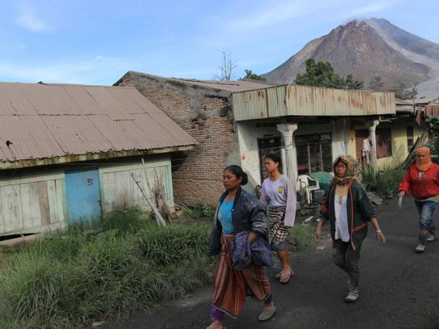 Indonesian villagers leave their houses at red zone area near the Sinabung volcano in Karo, North Sumatra on May 22, 2016. (AFP) 