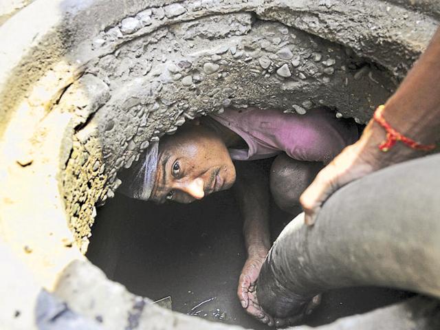 A worker cleaning a manhole without safety gear at Phase 11 in SAS Nagar. (Gurminder Singh/HT Photo) A worker cleaning a manhole without safety gear at Phase 11 in SAS Nagar. (Gurminder Singh/HT Photo)