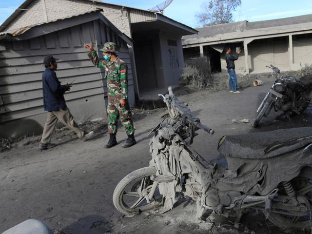 An Indonesian soldier helps others search an area following a deadly eruption of Mount Sinabung volcano in Gamber Village, North Sumatra, Indonesia May 22, 2016. (REUTERS) 
