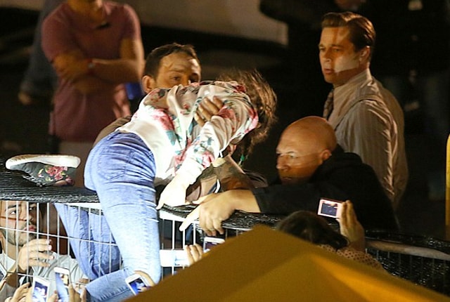 Pitt’s bodyguard lifted the girl to safety on the other side of the barricade. (Twitter)