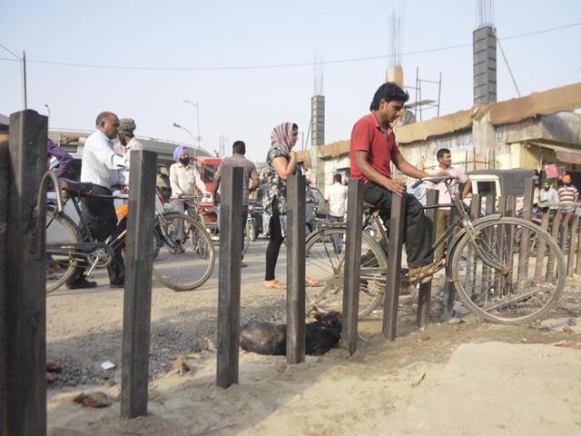 Cyclists moving through bollards installed to streamline traffic flow in the area.(Sameer Sehgal/HT Photo)