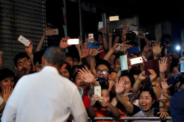 Residents react as Obama leaves after having a dinner at a restaurant in Hanoi. (REUTERS) Residents react as Obama leaves after having a dinner at a restaurant in Hanoi. (REUTERS)