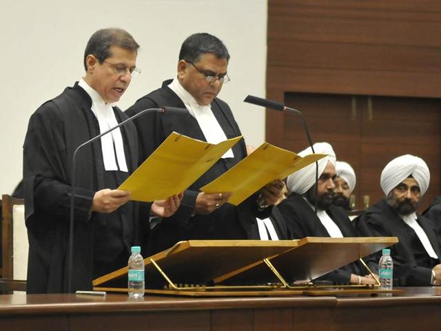 Acting chief justice of the Punjab and Haryana high court SJ Vazifdar (left) administrating the oath of office to justice Sudip Ahluwalia in Chandigarh on Monday.(Gurminder Singh/HT Photo)