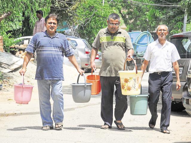 Residents of DLF City Phase 1 Block E carry water from a tanker. (Parveen Kumar/HT Photo) Residents of DLF City Phase 1 Block E carry water from a tanker. (Parveen Kumar/HT Photo)