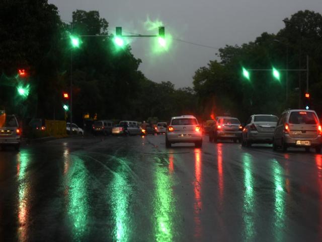 Colours from traffic signals are reflected on a wet road after rains stopped in New Delhi. (Sonu Mehta/ HT Photo)