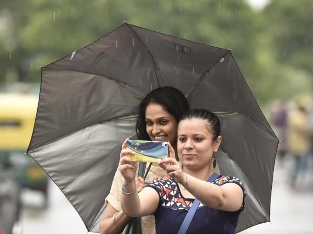Two women click a ‘selfie’ as light showers provided much-needed relief from the heat, in New Delhi. (Virendra Singh Gosain/ HT Photo)