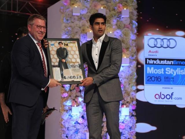 Vijender Singh receives his award. The professional boxer looks as charming in crisp suits as he does in fusion ethnicwear.  (Shivam Saxena/HT) 