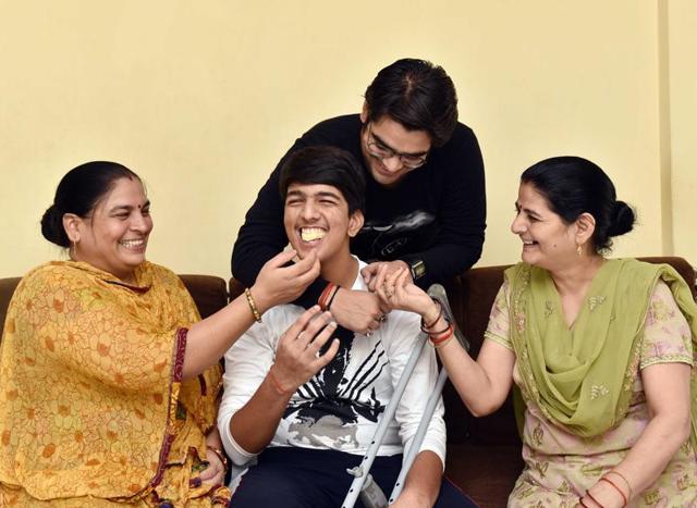 Shekhar Mishra (C) celebrates after HSC result with his mother Ragini Mishra (L), aunt Asha Shukla (R) and brother Devvart Mishra (Behind). 17-year-old Shekhar fell off a running train just two weeks before the HSC examinations. He gave the exams from an ambulance and scored 70% in his HSC boards at Mira Road near Mumbai on Wednesday, May 25, 2016.  (Pratham Gokhale) 