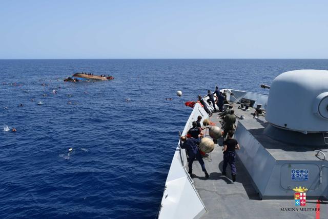 An Italian Navy ship approaches an overturned boat off the Libyan coast. (AP Photo) An Italian Navy ship approaches an overturned boat off the Libyan coast. (AP Photo)