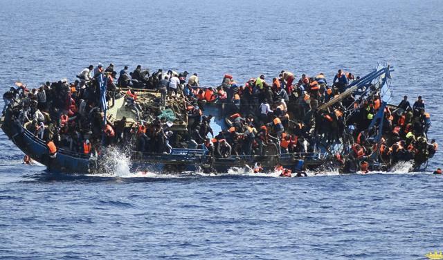 People try to jump in the water right before their boat overturns off the Libyan coast. (AP Photo) People try to jump in the water right before their boat overturns off the Libyan coast. (AP Photo)