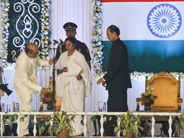 Officials adjust the microphone as Trinamool Congress party chief Mamata Banerjee prepares to take the oath of West Bengal chief ministership, in Kolkata on Friday.(AP)