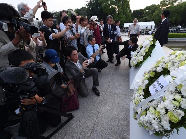 People jam to take pictures of the wreaths placed by Obama (R) and Abe (2nd R) in front of the cenotoph in the Peace Momorial park in Hiroshima. (AFP)