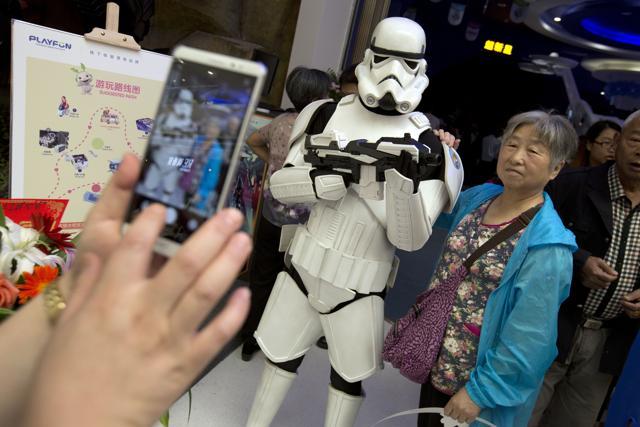 A Chinese woman poses for a smartphone photo with a worker dressed in a Storm Trooper costume of the Star Wars fame at the Wanda Mall. (AP)