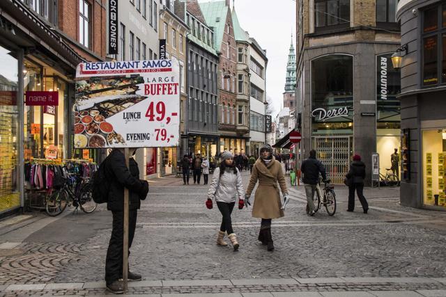 A man stands with a board advertising a restaurant in Copenhagen’s busy Stroeget shopping street (Getty Images) A man stands with a board advertising a restaurant in Copenhagen’s busy Stroeget shopping street (Getty Images)