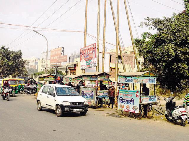 Shop owners said there is no space for visitors to park their vehicles as the open area is occupied by unauthorised vendors. (HT Photo) Shop owners said there is no space for visitors to park their vehicles as the open area is occupied by unauthorised vendors. (HT Photo)