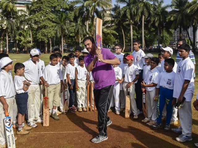 Former India cricketer Dilip Vengsarkar giving tips on batting stance, follow-through, and cover drives to kids at Oval Maidan on Saturday.(Kunal Patil/HT photo)