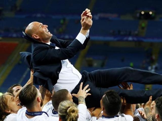 Real Madrid players give coach Zinedine Zidane the bumps as they celebrate winning the Uefa Champions League. (Reuters Photo)