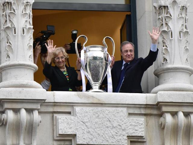 Real Madrid president Florentino Perez (R) and mayor of Madrid, Manuela Carmena, wave as they show the trophy from Madrid town hall's balcony, a day after winning the Uefa Champions League final football match against Club Atletico de Madrid, held in Milan, Italy. (AFP Photo)