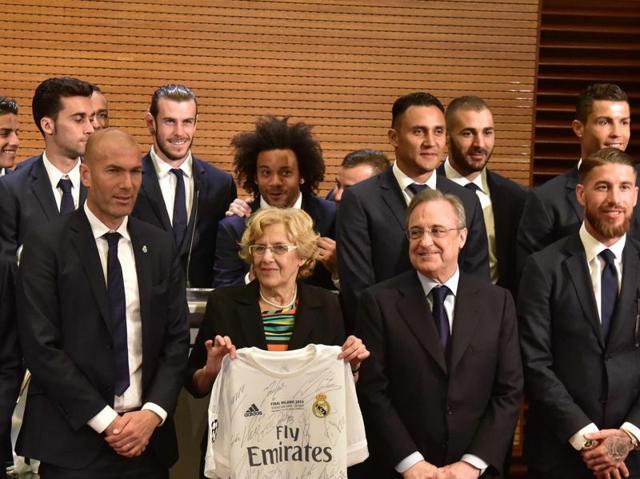 Mayor of Madrid, Manuela Carmena (C), poses with a Real Madrid jersey surrounded by the team in Madrid town hall on May 29. (AFP Photo)