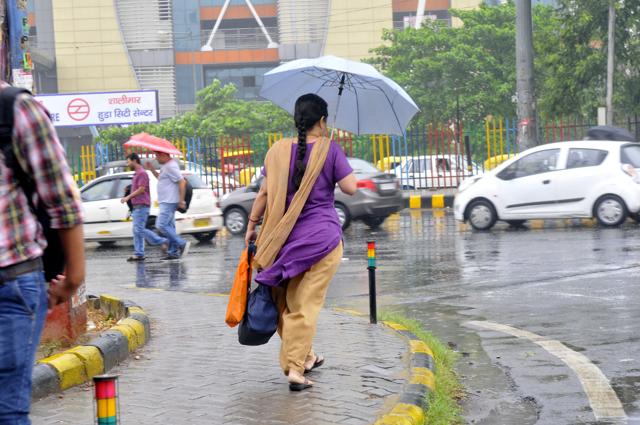 A woman going towards Huda City Centre Metro station as downpour accompanied by winds continued in Gurgaon on Monday morning. (Abhinav Saha/HT Photo) A woman going towards Huda City Centre Metro station as downpour accompanied by winds continued in Gurgaon on Monday morning. (Abhinav Saha/HT Photo)
