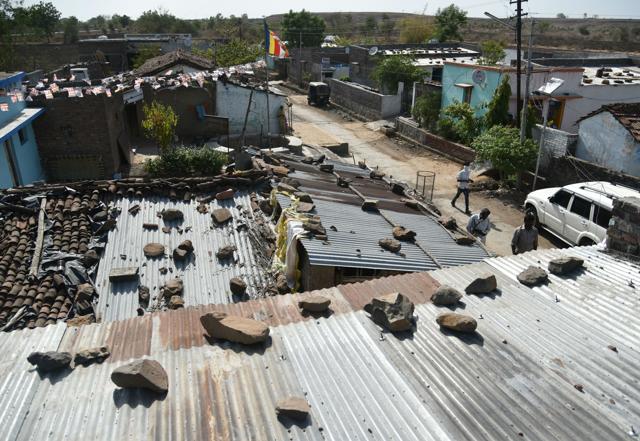 Villagers walk past houses struck by debris after fire at the ammunition depot in Pulgaon. (AFP) Villagers walk past houses struck by debris after fire at the ammunition depot in Pulgaon. (AFP)