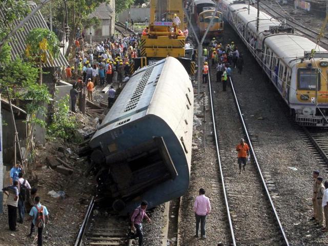 Railway employees try hard to remove an empty coach of a long-distance train which derailed near Lower Parel station throwing suburban lifeline out of gear in the first half of the day. (bhushan koyande)