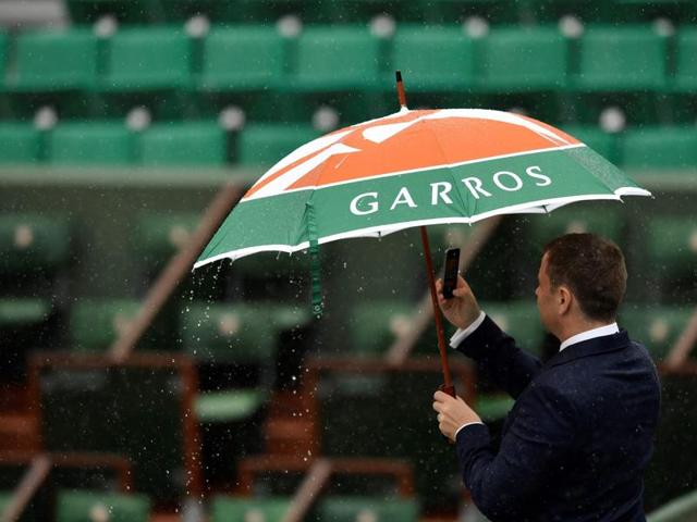 A spectator uses an umbrella as rain falls at the French Open. (REUTERS) A spectator uses an umbrella as rain falls at the French Open. (REUTERS)