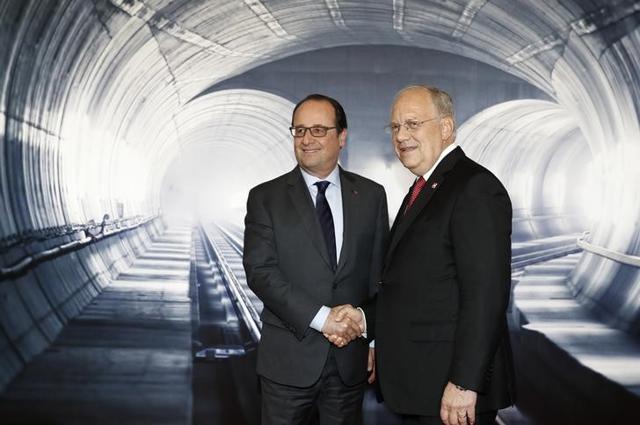 Swiss Federal President Johann Schneider- Ammann, right, speaks with French President Francois Hollande, left, on the opening day of the Gotthard rail tunnel, the longest tunnel in the world. (Reuters)