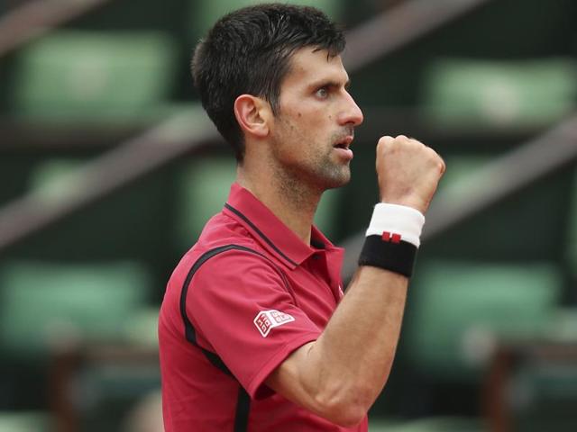 Novak Djokovic calls over a ball boy and teaches him his new post-match celebration after defeating Roberto Bautista Agut. (AP) Novak Djokovic calls over a ball boy and teaches him his new post-match celebration after defeating Roberto Bautista Agut. (AP)