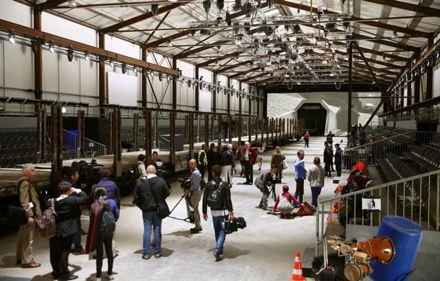 Journalists stand in front of mock gates of the NEAT Gotthard Base Tunnel.